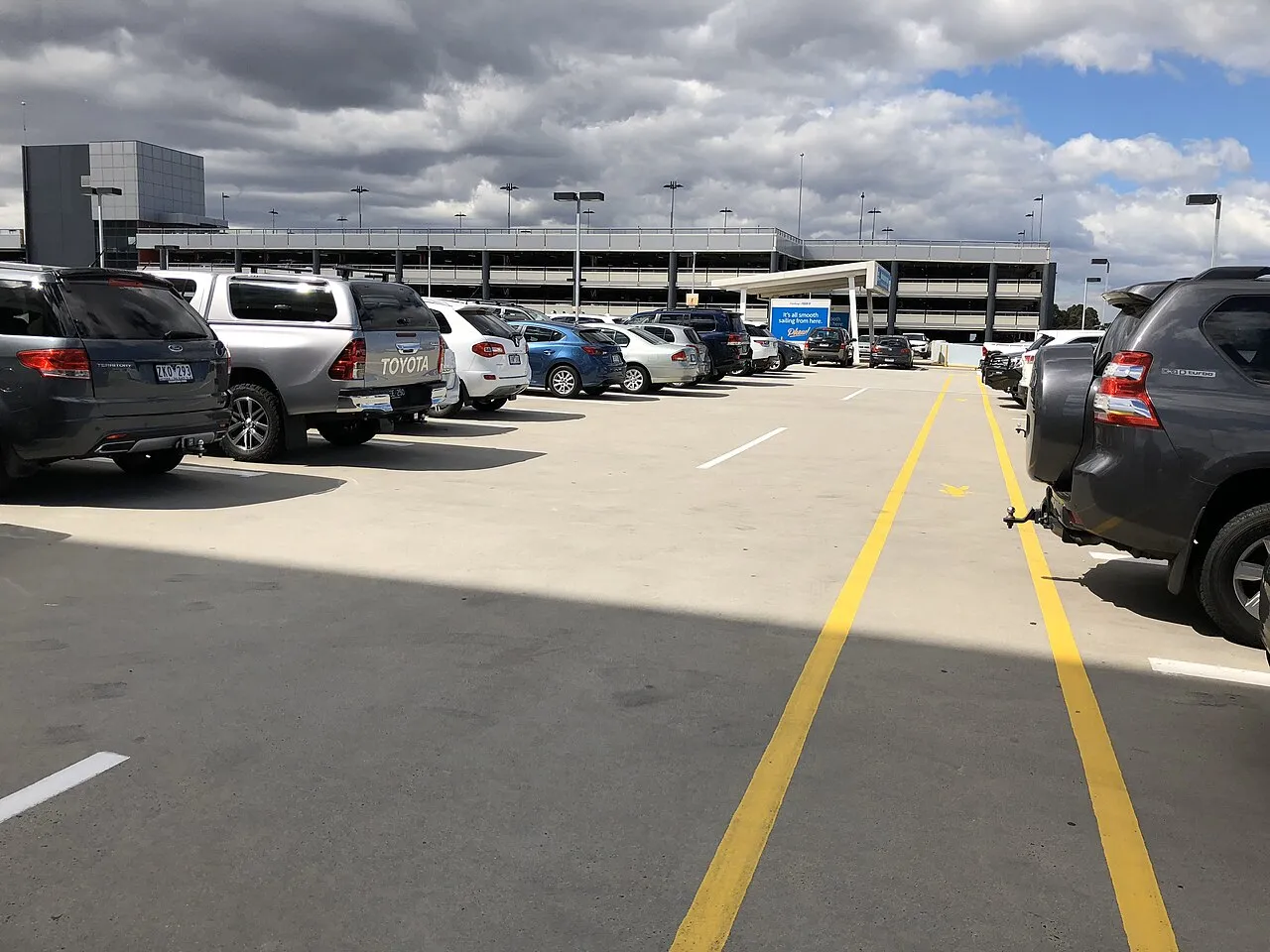 Rooftop level of a Melbourne Airport car park with parked cars