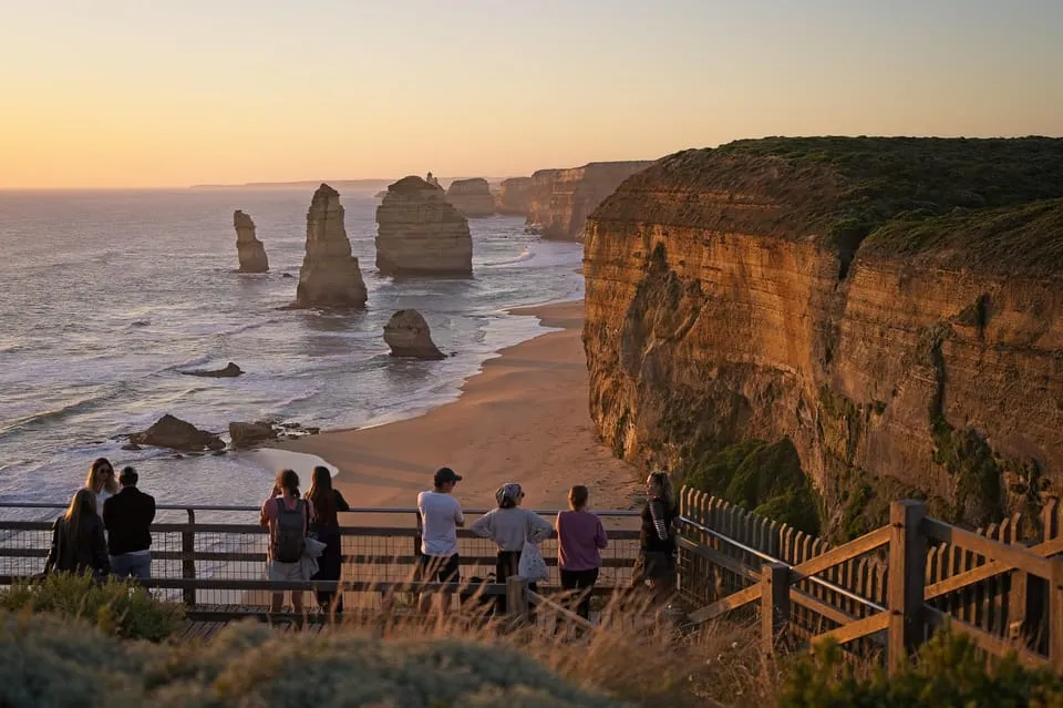 People at a timber lookout above limestone stacks in the sea